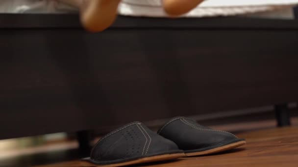 男人的腿从床上出来 穿着灰色的拖鞋 走在家里 — 图库视频影像