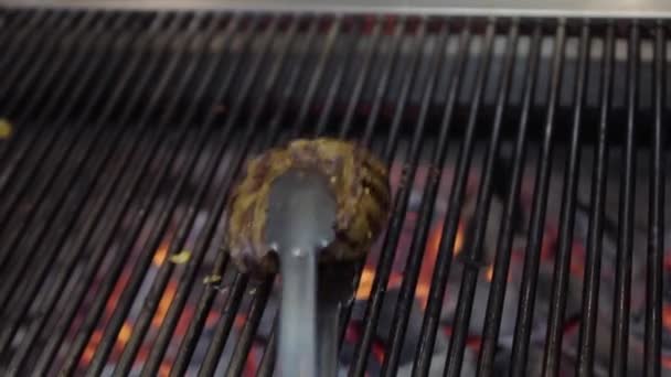 厨师在烤架上准备好吃的肉 用金属钳把它翻过来 红色的糖在底部 餐厅厨房的食物准备工作 — 图库视频影像