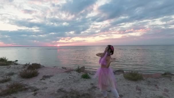甜美的年轻女子 穿着粉色衣服 化着灿烂的妆容 带着烟雾弥漫的炸弹在河岸上跳舞 一个漂亮的性感女孩的舞蹈 她的发型很美 有花朵 慢动作 — 图库视频影像