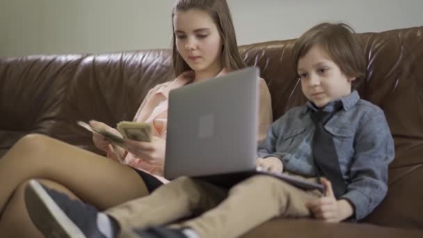 Komoly Nővére Öccse Bőrkanapén Laptopos Fiú Lány Aki Pénzt Számolja — Stock videók