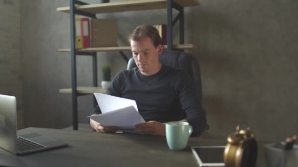 Genç Sarışın Üzgün Adam Modern Temiz Ofiste Oturuyor Evrakları Okuyor — Stok video