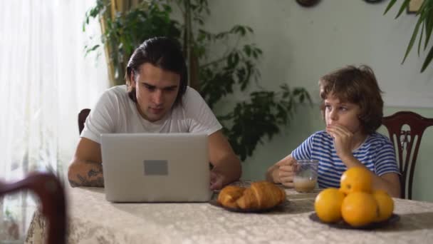 Liten Söt Pojke Sitter Köksbordet Äter Croissant Med Cappuccino Och — Stockvideo