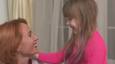 Mutlu bir anne ve kızın yakın plan portresi. İyi vakit geçiriyorlar ve oynaşıyorlar..