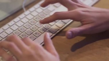 Videoyu kapat, elleri ofisteki klavyede daktilo ediyor.