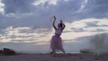 Açık havada dans eden pembe elbiseli, parlak makyajlı güzel kız..