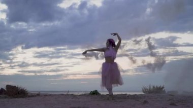 Açık havada dans eden pembe elbiseli, parlak makyajlı güzel kız..