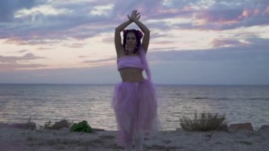 Açık havada dans eden pembe elbiseli, parlak makyajlı güzel kız..