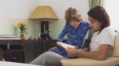 Ağabeyi küçük erkek kardeşine kitap okuyor. Uyurgezer kardeşler bir sandalyede oturup sabahları ne okuduklarını tartışırlar.