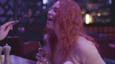 İki tatlı kız arkadaş modern bir restoranda yemek yiyorlar..