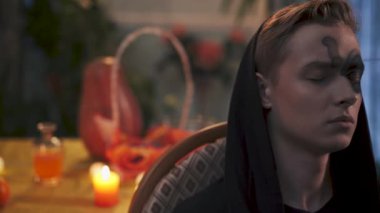 Cadılar Bayramı. Koyu renk elbiseli genç bir sandalyede oturuyor, video. 