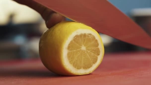 大きなシェフナイフでレモンをスライス調理の手を閉じます 近代的なレストランでの健康的な食品の準備 — ストック動画