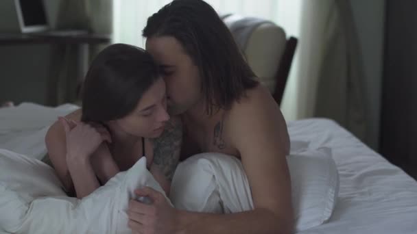 Handsome Man Cuddles His Girl Lying Bed Kissing Her Tenderly — Stock Video