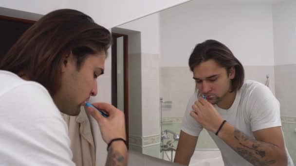 Τύπος Καθαρίζει Δόντια Του Μπροστά Από Έναν Καθρέφτη Στο Μπάνιο — Αρχείο Βίντεο