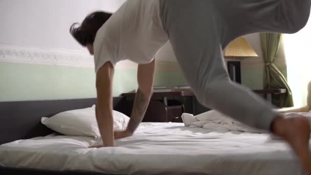 Красивый Молодой Человек Пижаме Запрыгивает Постель Укрывается Одеялом Медленное Движение — стоковое видео