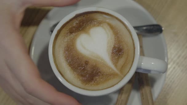 女人的手拿着一杯白咖啡 紧紧地放在盘子里 女士在咖啡店里喝咖啡 盘子里有勺子和两根糖 顶部视图 — 图库视频影像