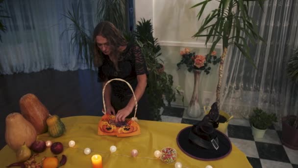 万圣节视频 女人吃的是芥末蠕虫 女巫准备万圣节 南瓜和水果旁边桌子上的女巫帽 — 图库视频影像