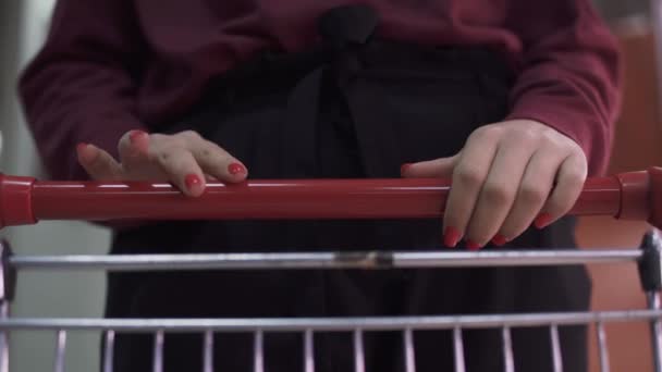 超级市场女性手拉手的特写镜头 雌性手模仿在推车上弹奏的钢琴 女用手把产品放进购物车的布景 — 图库视频影像