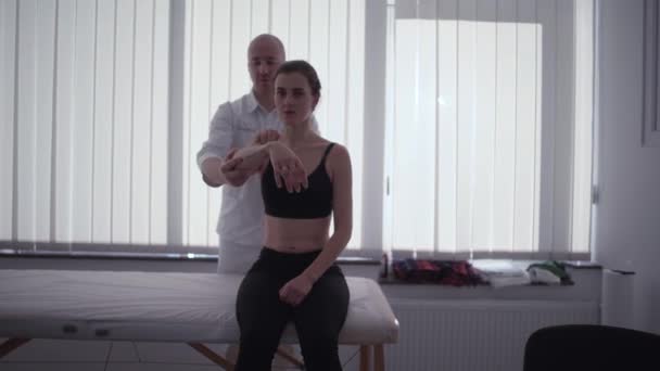 Doktor Hastanın Kolunu Esnetir Osteopat Taki Resepsiyonda Güzel Bir Kız — Stok video