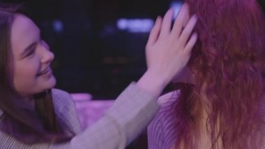 Mavi ışıkta birlikte iki güzel lezbiyen çiftin portresi. Bir kız arkadaşının saçına dokunuyor, kızıl saçlı arkadaşı onu alnından öpüyor. Aşk ve ilişki kavramı