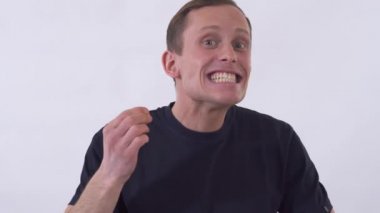 Genç, çılgın, komik adam tuhaf suratlar yapıyor, asık suratlı..