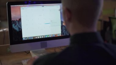 Ofisteki modern bilgisayarın önünde çalışan bir adamın arka plan videosu