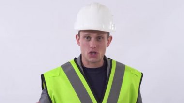 Üniformalı müteahhit portresi konuşuyor ve kameraya yakından bakıyor. Beyaz bir arka planda stüdyoda çekim yapmak.