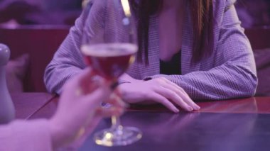 Kadın, bardağını alkollü bardakla tutuyor. Tanımlanamayan bir kadın reddedici jestler yapıyor. Alkol almak istemiyor. Sağlıksız yaşam tarzı