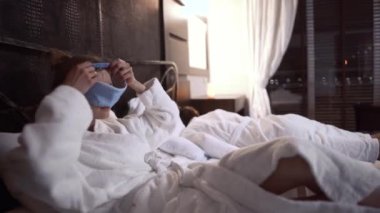 Yetişkin bir kadın yatağa uzanır ve uyumaya hazırlanırken yüzüne uyku maskesi takar. Kocası yakında uyuyor. Çift modern otel odasında dinleniyor.