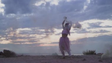 Açık havada dans eden pembe elbiseli, parlak makyajlı güzel kız..