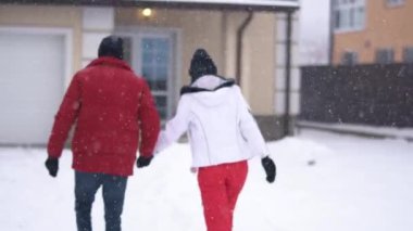 Evin arka bahçesinde el ele tutuşan kadın ve sakallı adamın videosu.