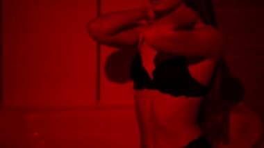 Ateşli genç bayan banyoda kırmızı ışıkta kendini ıslatıyor. Yarı çıplak kız kendini okşuyor, vücudu ıslak, saçları akıyor. Kamera yukarı hareket ediyor