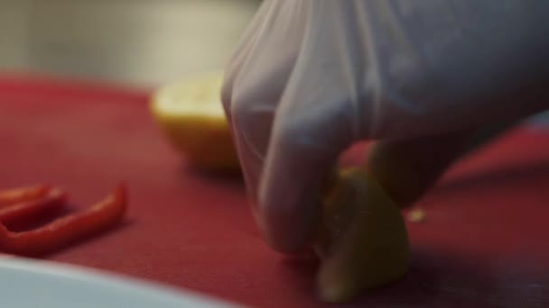手拿着白橡胶厨师的手套 用一把切下柠檬片的小刀烹调 — 图库视频影像