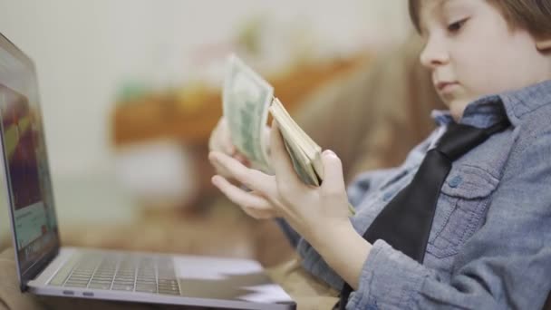 Het Jongetje Spijkerjasje Zit Leren Bank Voor Laptop Het Geld — Stockvideo