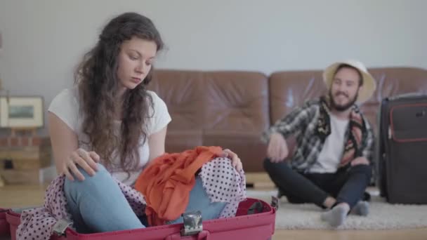 Üzgün Kadın Planda Bavulda Otururken Mutlu Koca Eşyalarını Topluyor Video — Stok video