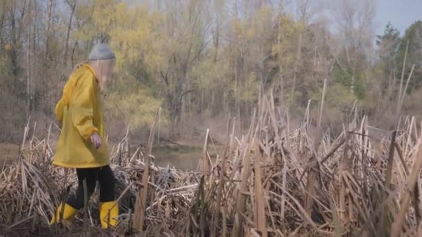 Ciało Człowieka Chodzącego Ostrożnie Krok Kroku Bagnach Żółtych Butach Płaszczu — Wideo stockowe