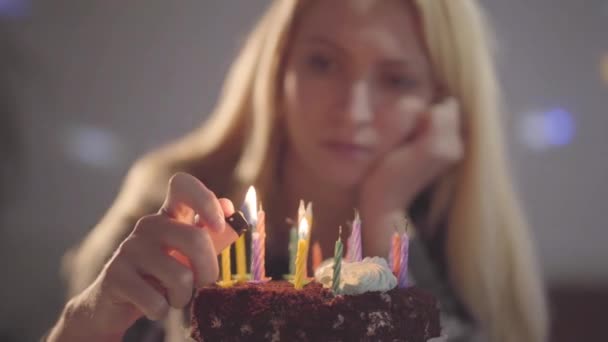 小さなケーキ照明ろうそくの前に座っている孤独な悲しい女の子 不幸な女性が誕生日パーティーを開く うつ病 気分不良 孤独の概念 — ストック動画