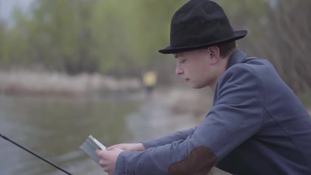 Retrato Elegante Pescador Una Chaqueta Gorra Campo Sienta Cerca Río — Vídeo de stock