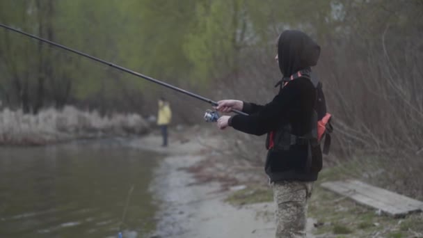 Уверенный Молодой Рыбак Брюках Цвета Хаки Рано Утром Крутит Рыбалку — стоковое видео
