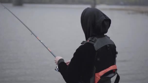 Уверенный Молодой Рыбак Брюках Цвета Хаки Рано Утром Крутит Рыбалку — стоковое видео