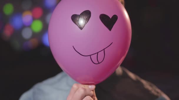 Retrato Jovem Confiante Chapéu Aniversário Removendo Balão Rosa Com Rosto — Vídeo de Stock