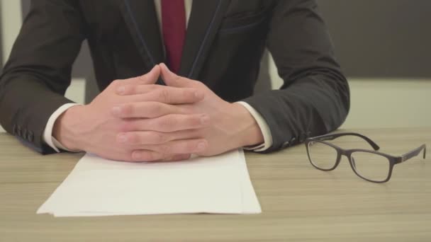 Неузнаваемый Человек Костюме Сидит Столом Скрещенными Пальцами Перед Пустыми Бумагами — стоковое видео