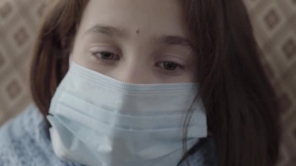 Menina Doente Triste Com Máscara Médica Rosto Olhando Para Baixo — Vídeo de Stock