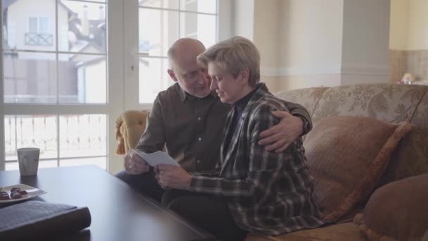 Pareja Ancianos Sentados Sofá Viendo Viejas Fotografías Hombre Abrazar Mujer — Vídeo de stock