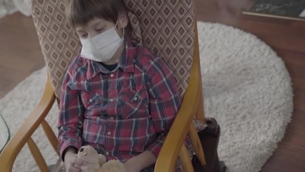 Video Little Ill Boy Sitting Armchair Medical Mask Face Holding — Stock Video