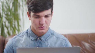 Evde dizüstü bilgisayarın önünde oturan genç adam. Posta kutusunu kontrol eden esmer bir adamın portresi. Aletlere bağımlılık. Serbest konsept