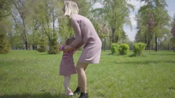 年轻的母亲在大自然面前手摇女儿 在公园里玩的女人和小孩 开玩笑 玩得开心 户外公园的家庭度假 — 图库视频影像