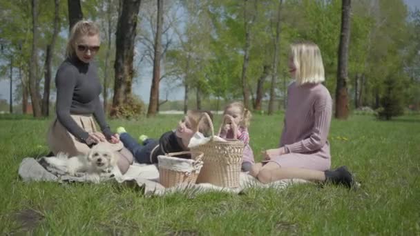 Zwei Junge Mütter Mit Ihren Kindern Sitzen Einem Frühlingstag Auf — Stockvideo