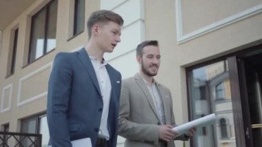 Resmi olarak kendine güvenen iki adamın portresi terasta yürürken yeni proje, iş konsepti, video tartışmaları... 