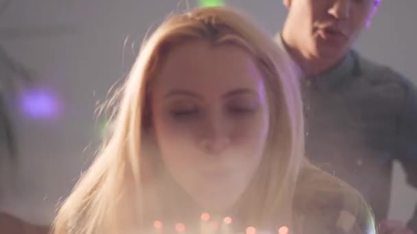 Das Blonde Mädchen Bläst Kerzen Auf Der Torte Aus Der — Stockvideo