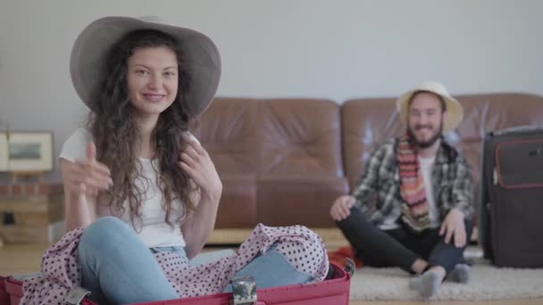 Portrait Happy Woman Sitting Suitcase Bearded Man Sitting Next Sofa — Stockvideo